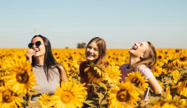 woman in white and black striped shirt standing on yellow sunflower field during daytime